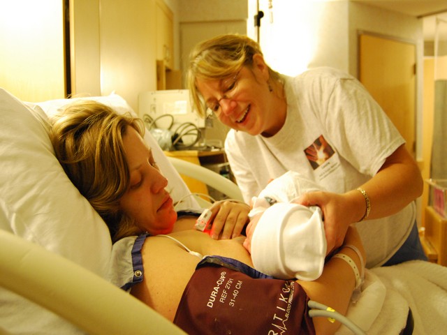 Hartford area birth doula Laura assisting with initial feeding after a safe, happy birth.